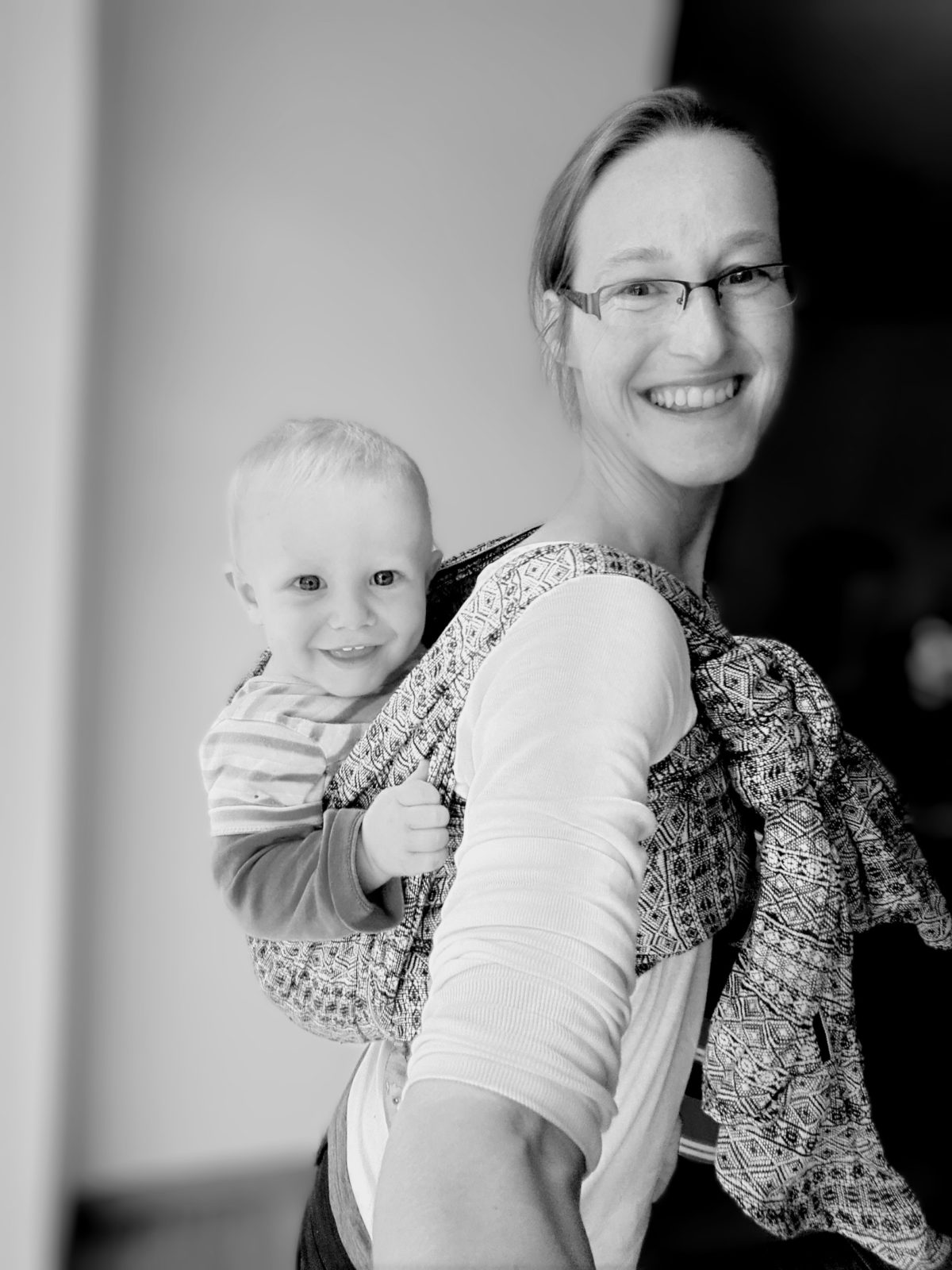 Elternteil trägt Baby im Arm – liebevolle Bindung